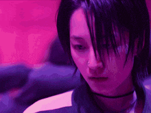 a close up of a person 's face with purple lights behind them