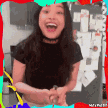 a woman in a black shirt is smiling in a colorful frame with mayward written on it