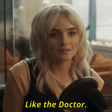 a woman is sitting in front of a microphone with the words like the doctor on the bottom