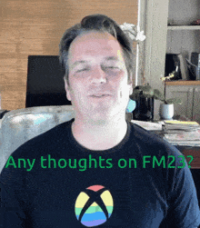 a man wearing a black shirt that says " any thoughts on fm232 " on it
