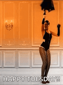 a woman in a black bodysuit is holding an umbrella in her hand and dancing in a room .