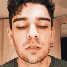 a close up of a man 's face with a cross in his ear