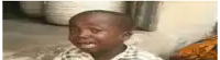 a young boy is crying and making a funny face while sitting on the floor .