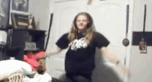 a girl is dancing in a bedroom wearing headphones and a black shirt .