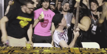 a man in a pink shirt with the word boss on it stands in front of a crowd