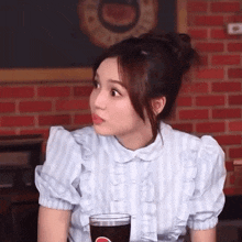 a woman is sitting at a table with a glass of pepsi