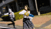 a woman in a white shirt and a blue skirt is running away from a robot