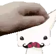 a hand is holding a cartoon character with a mustache and a pink nose .