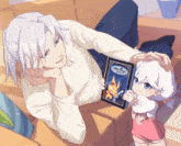 a man is laying on a couch holding a book that says ' a fairy ' on it