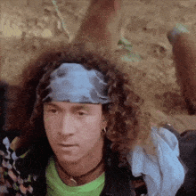 a man with curly hair wearing a blue headband