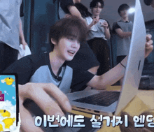 a man is playing a game on a laptop with korean writing on the screen