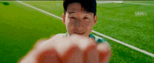 a close up of a person 's fist on a soccer field