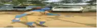 a blurry picture of a person standing in a dirt field with a white car in the background
