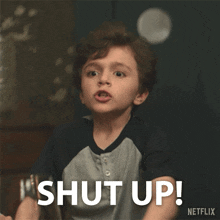 a young boy is making a funny face with the words shut up written below him