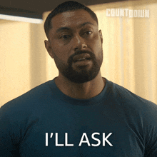 a man with a beard is wearing a blue shirt that says " i 'll ask "