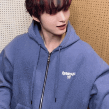 a person wearing a blue hoodie that says open your eyes on it