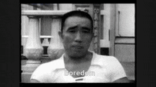 a man in a white shirt says boredom in a black and white video