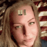 a woman 's face is shown with a picture of a building on her forehead and an american flag behind her