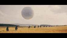 a group of people walking in a field with a large white ball in the background