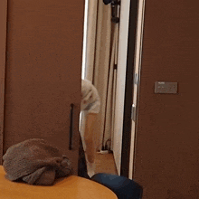 a person is standing in front of a door with a light switch on the wall