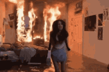 a woman in a diaper is walking through a room that is on fire .