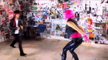 a man and a woman are dancing in a room with posters on the wall