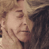 a close up of a woman 's face with a man 's hand touching it
