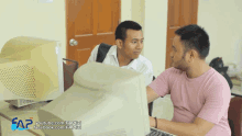 two men are looking at a computer screen with the words sap youtube.com and facebook.com