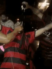 a man in a red and black striped shirt with the number 2 on the back
