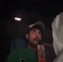 a man wearing a green sweater with the letter l on it