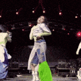 a woman is dancing on a stage wearing a shirt that says ' jesus ' on it