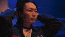 a close up of a person holding their head with their hands .