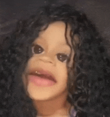 a little girl wearing a wig and making a funny face .