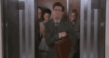 a man in a suit is walking in a room with a blurry background .