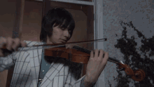 a person playing a violin in front of a door