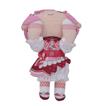 a stuffed doll with pink hair and a white dress