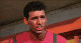 a man wearing a red shirt that says ' jesus ' on it is making a funny face