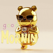a gold teddy bear wearing sunglasses and holding a diamond with the words good morning behind him