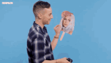 a man in a plaid shirt is holding an ice cream cone in front of his face with cosmopolitan written on the bottom