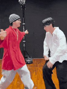 two young men are dancing in front of a basketball hoop that says ' hoop '