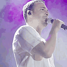 a man singing into a microphone while wearing ear buds