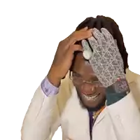 a man in a white suit is smiling and covering his face with his hand