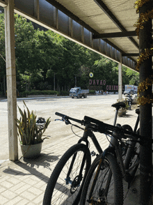 two bicycles are parked under a canopy with a sign that says " davao oriental " on it