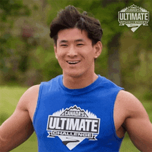 a man wearing a blue tank top that says canada 's ultimate challenge on it