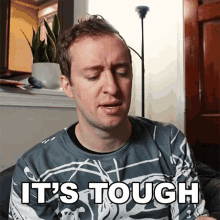 a man wearing a sweatshirt that says it 's tough