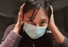 a woman wearing a face mask has a sticker on her jacket that says " arctic cat "