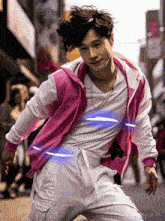 a man wearing a pink jacket and white pants is dancing