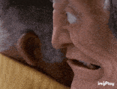 a close up of an elderly man 's face with his mouth open and his eyes closed .