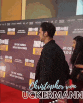 a man and woman standing on a red carpet with the name christopher von uckermann