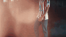 a man wearing a red and white striped shirt with the number 3 on the front